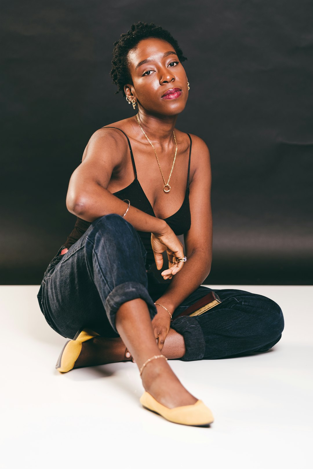 topless woman in blue denim jeans sitting on floor