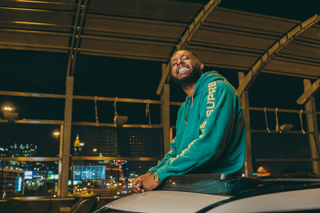 man in blue hoodie standing beside table