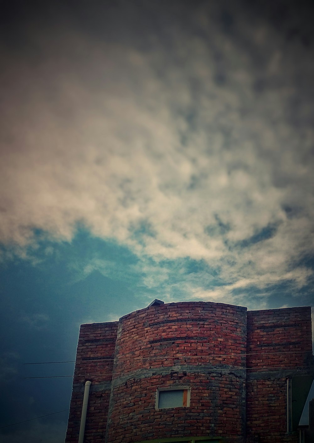 brown concrete building under cloudy sky during daytime