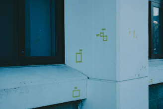 Consultant examining a building wall closely with a clipboard in hand.