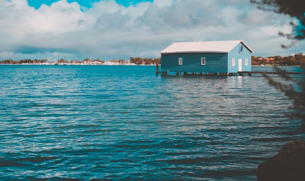 blue and white house on body of water during daytime