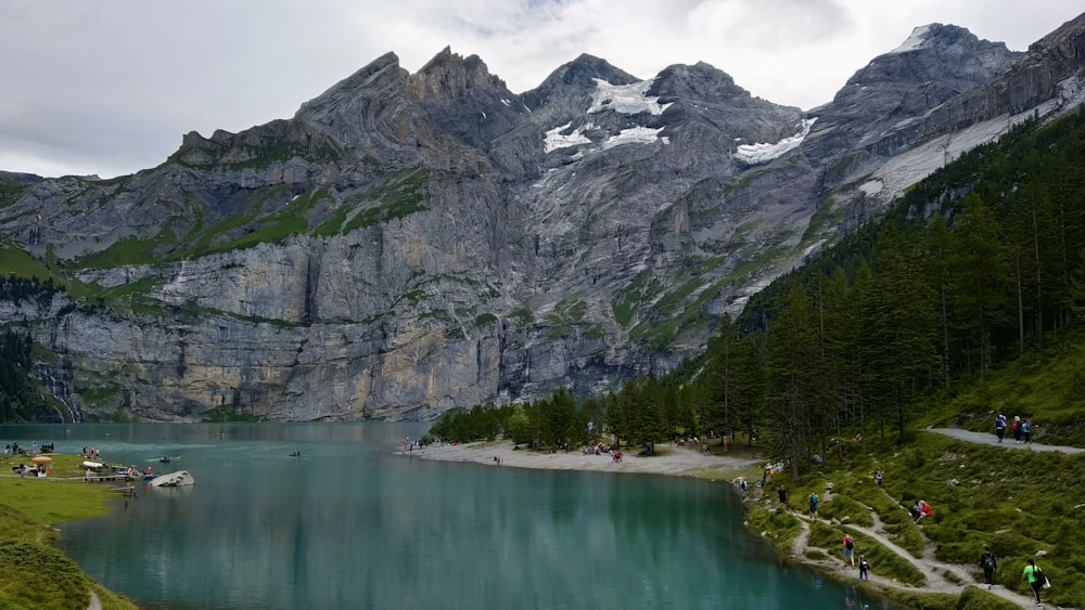 lake near gray rocky mountain during daytime
