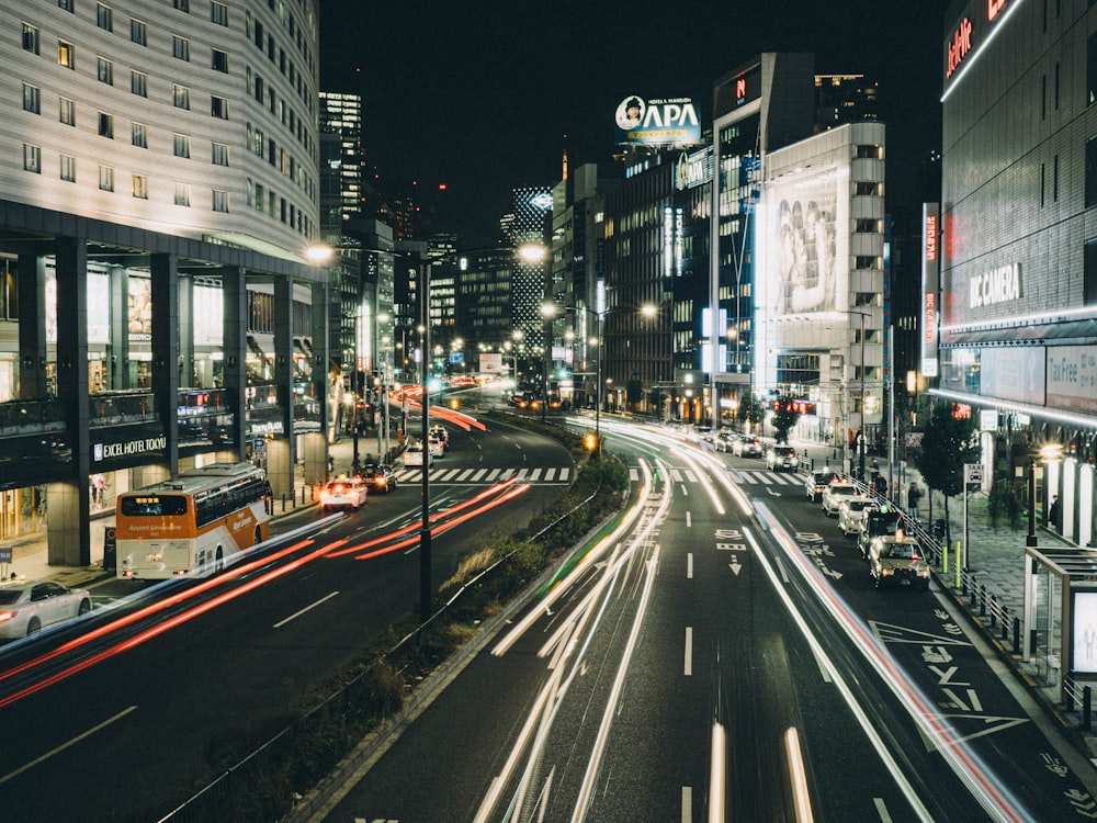 cars on road near high rise buildings during night time