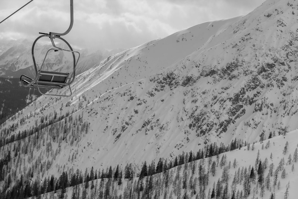 grayscale photo of cable car over snow covered mountain