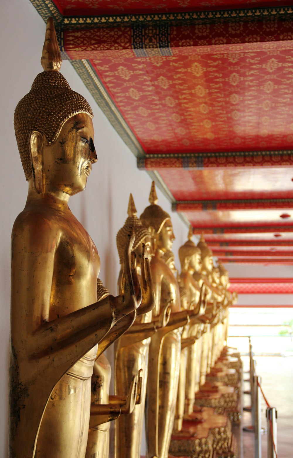 gold buddha statue in front of red and gold building