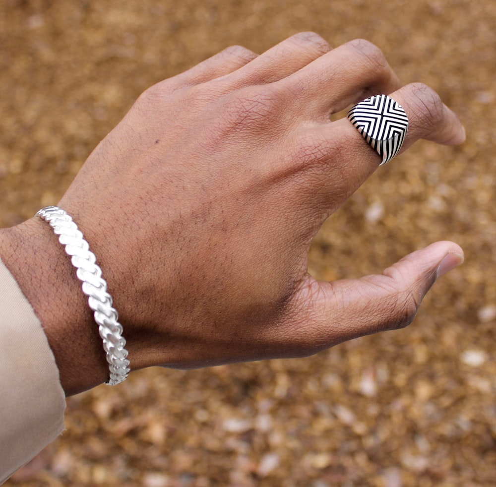 person wearing silver and white beaded bracelet