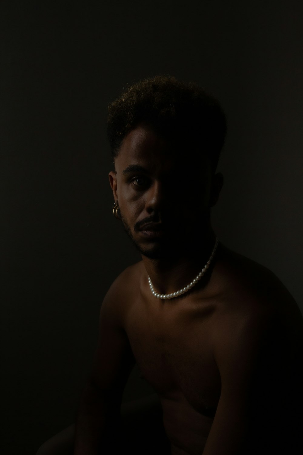 topless man wearing silver necklace