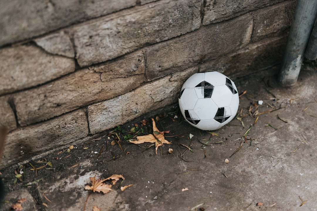 white and black soccer ball on gray concrete wall