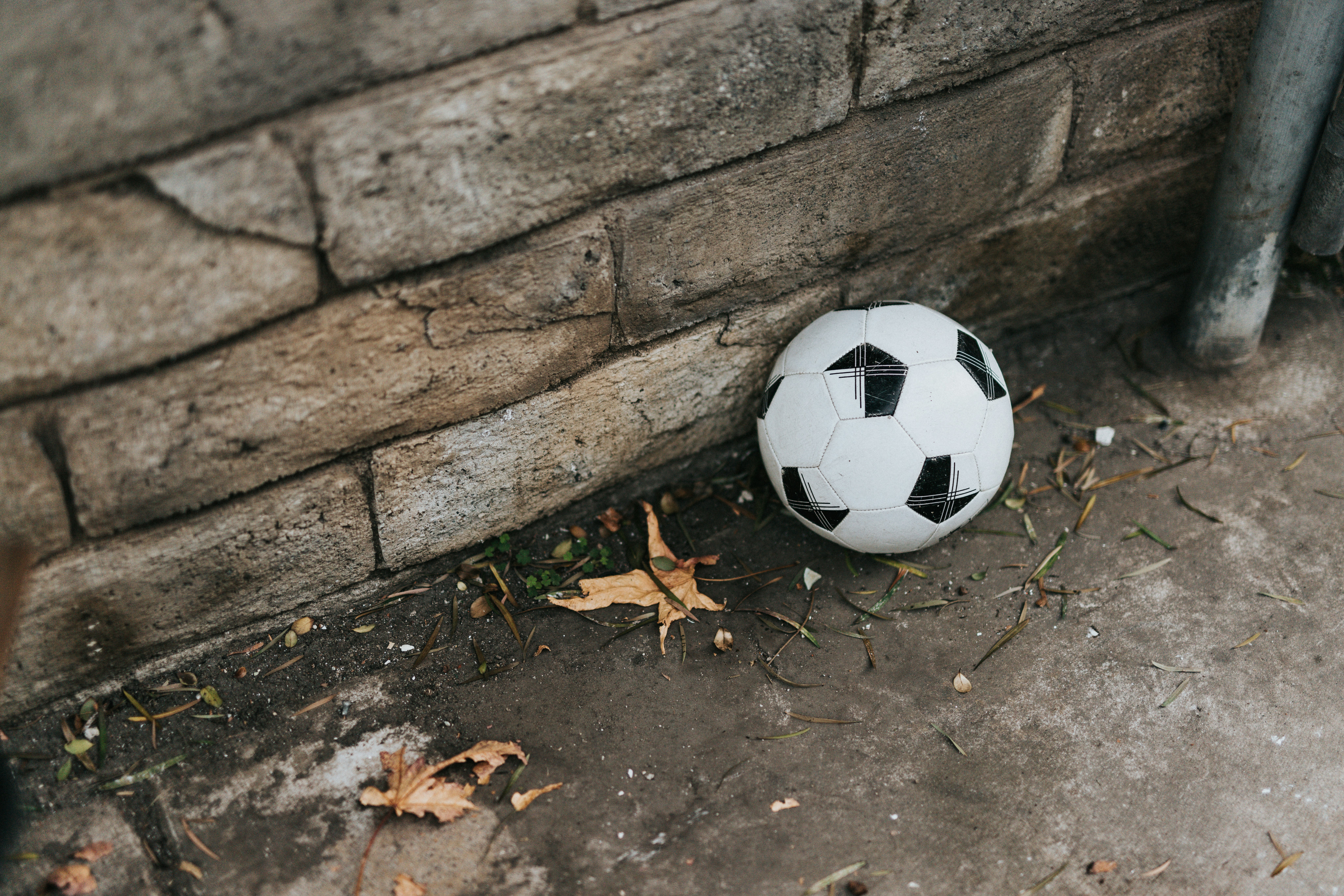 white and black soccer ball on gray concrete wall