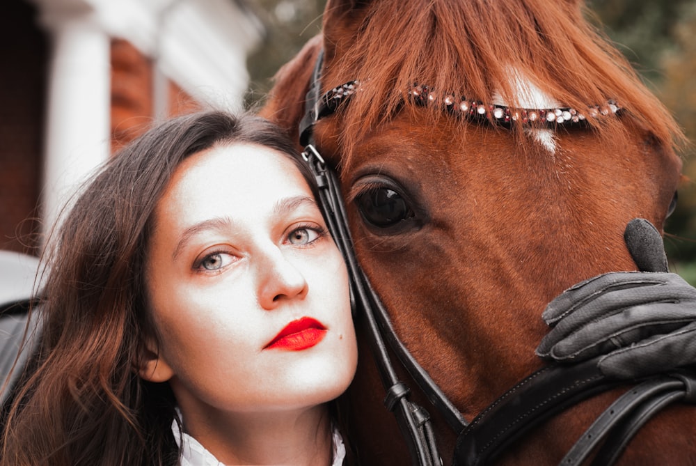 woman in black leather jacket beside brown horse