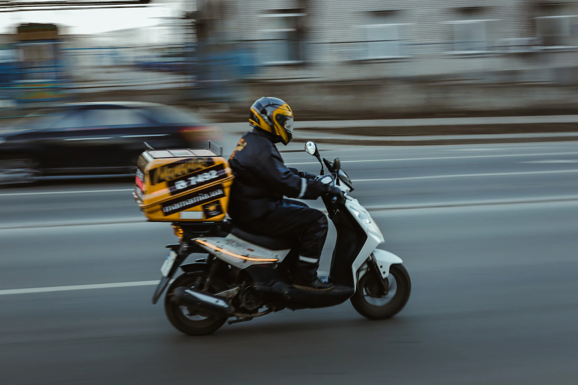 Delivery rider on a motorcycle with a parcel box