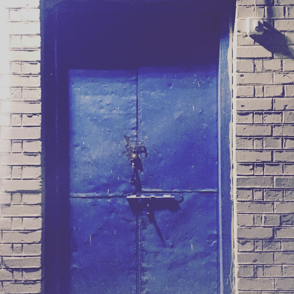 blue wooden door with black metal door lever