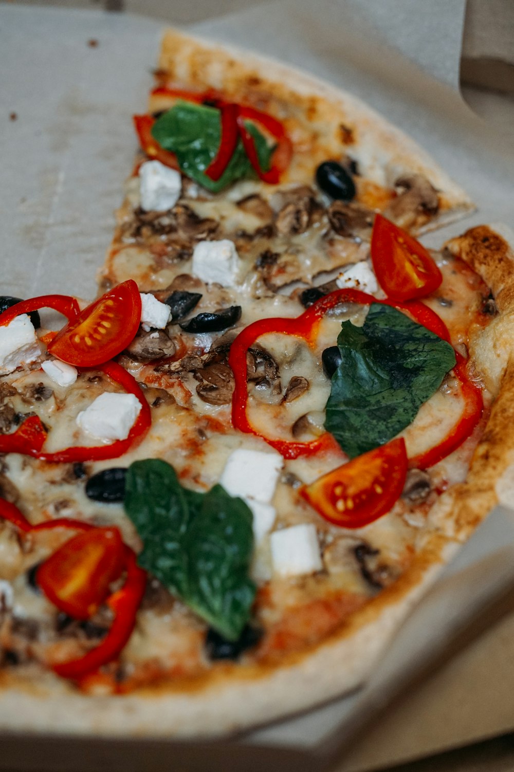 pizza with green leaves and red sliced tomatoes