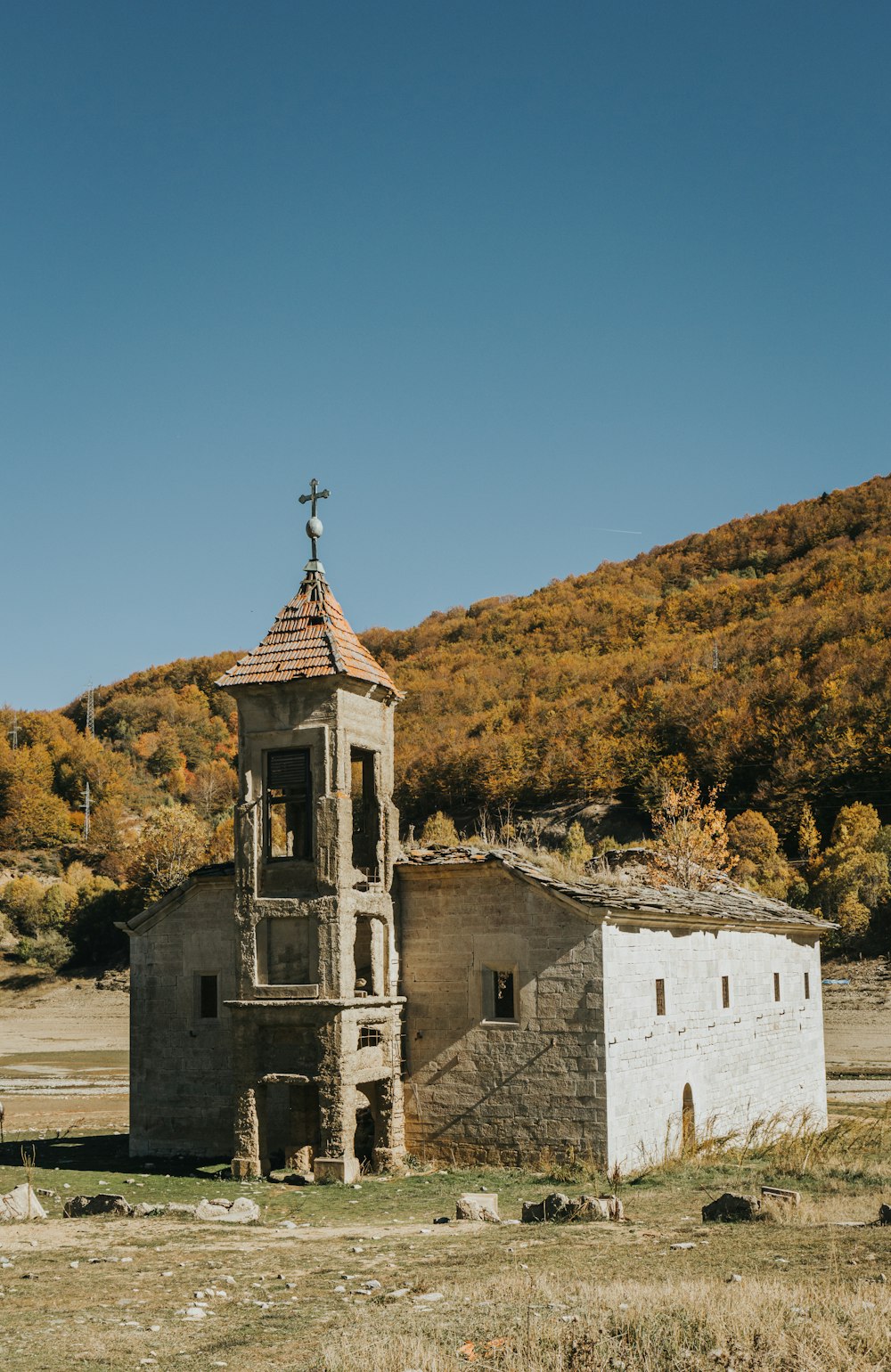 edifício de concreto branco e marrom perto de árvores verdes sob o céu azul durante o dia