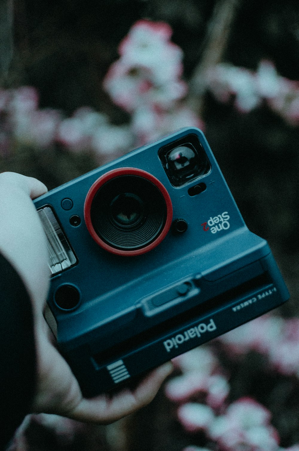 person holding blue and black polaroid camera