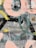 A textured surface featuring overlapping layers of spray paint and brush strokes in an abstract design. The image includes a mix of pastel pinks, yellows, and greens against a backdrop of gray and black. There are signs of weathering and rust on the surface, adding character to the artwork.