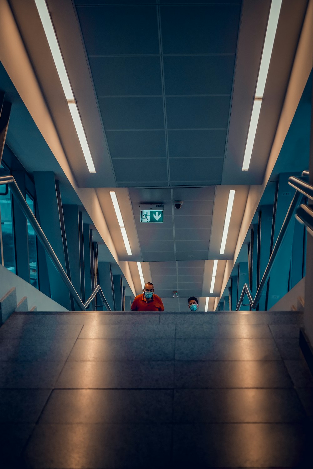 person in red jacket sitting on gray concrete floor