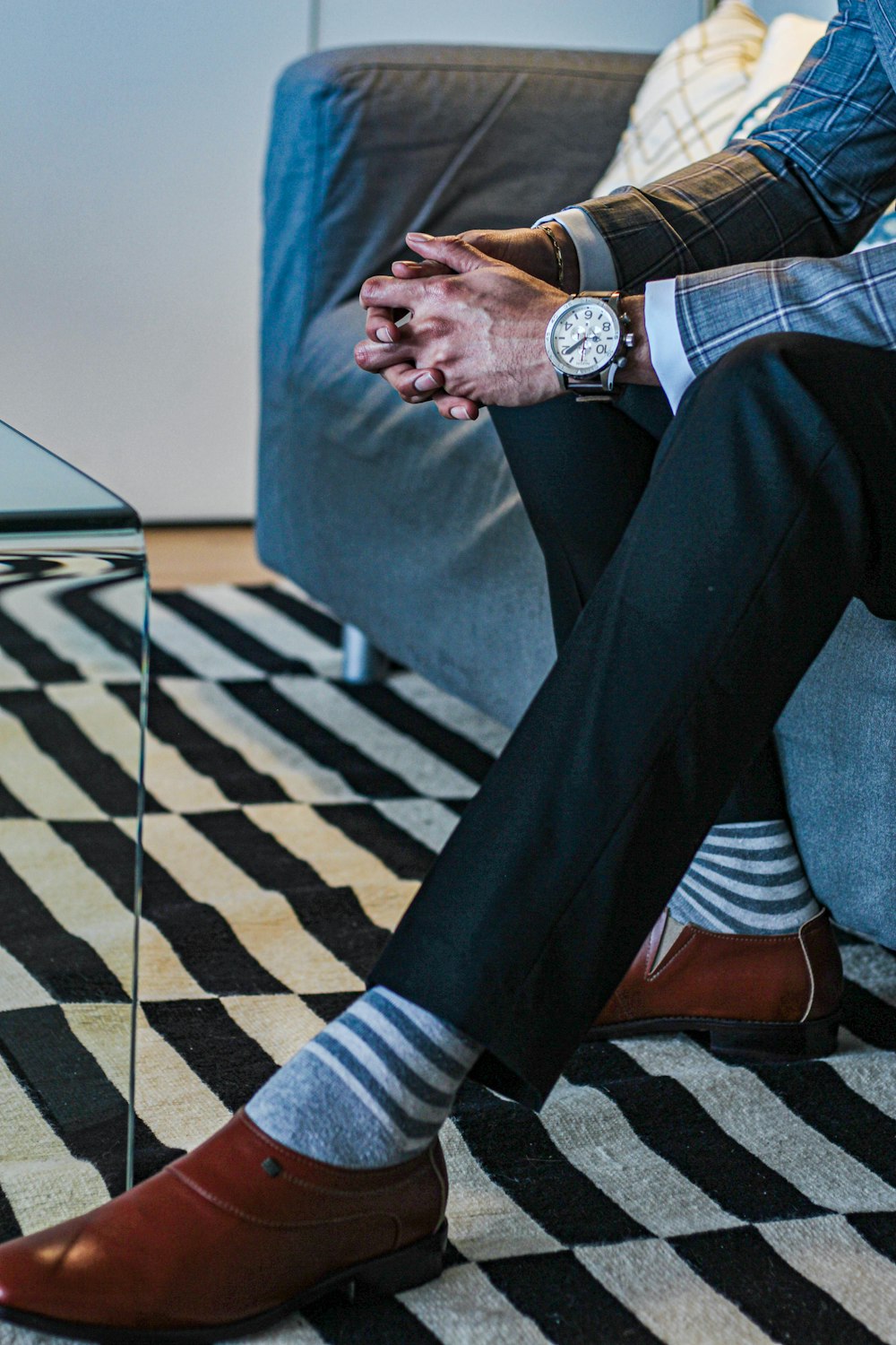 man in black formal suit standing on blue and white checkered floor