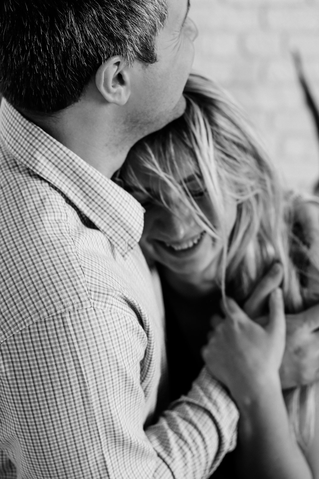 man and woman kissing grayscale photo