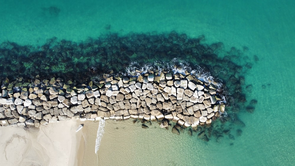 white and black rocks on body of water during daytime