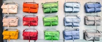 A colorful display of durabag handbags in various sizes arranged on a wooden table.