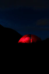 Colorful party tent with transparent sides lit up at dusk.