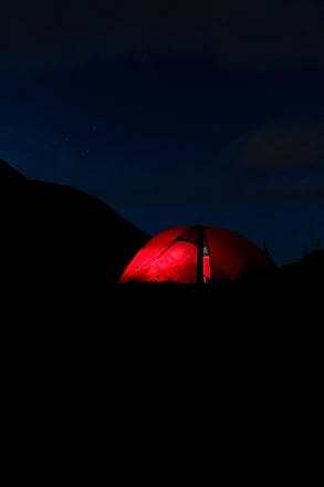 A vibrant circus tent with colorful lights illuminating the night sky, symbolizing energy and excitement.
