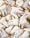 A scattered arrangement of numerous white molar teeth set against a soft background. Each tooth varies slightly in size and angle, giving a natural, organic feel to the collection.