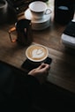 une personne qui pose une tasse de café sur une table