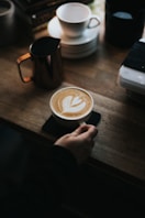 une personne qui pose une tasse de café sur une table