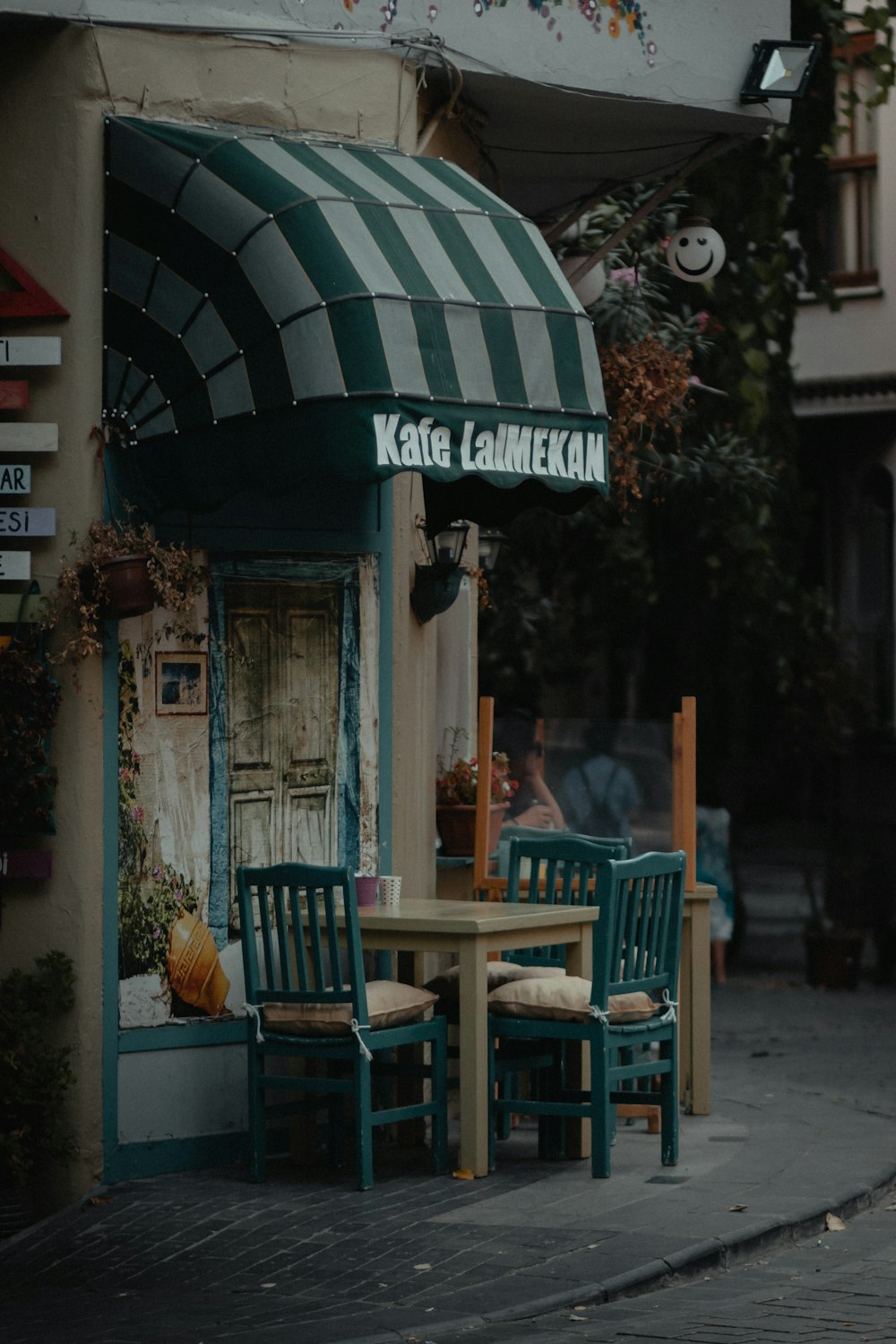 緑と白の店の近くにある茶色の木製の椅子とテーブル