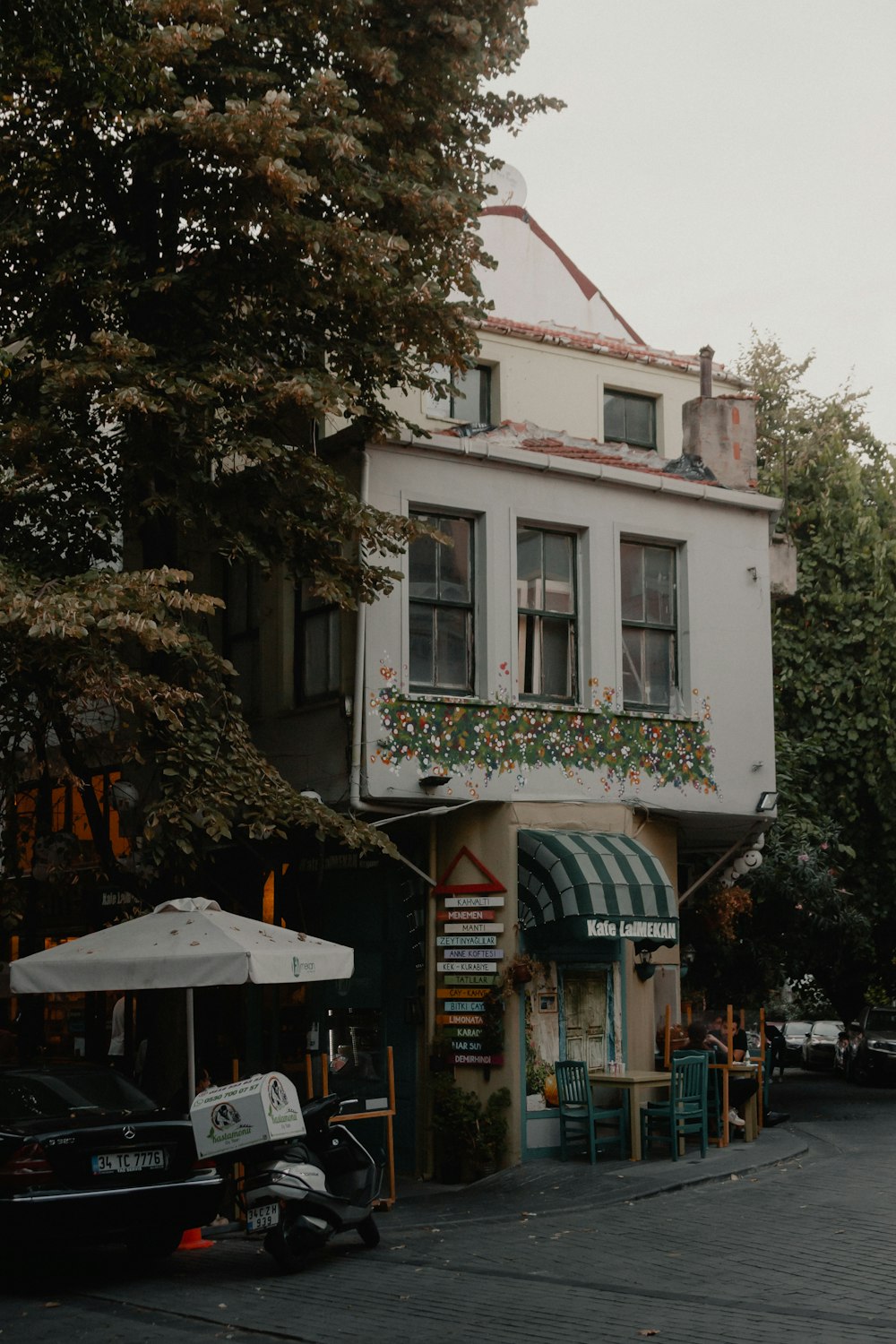 white and green concrete building near green tree during daytime