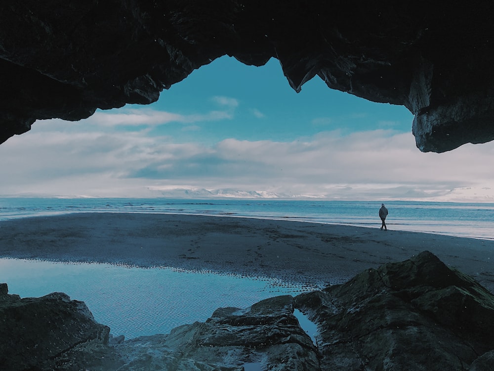 person walking on seashore during daytime