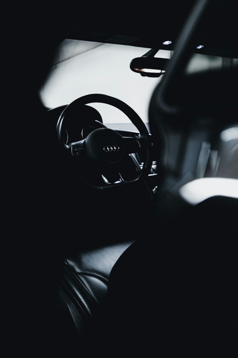 black steering wheel in grayscale photography