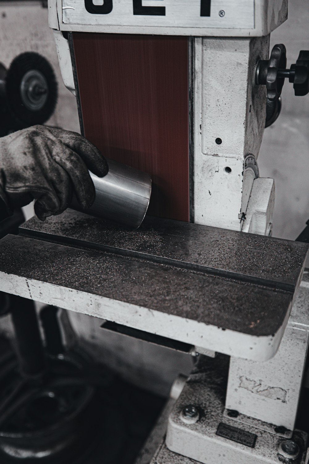 person holding silver and red metal tool