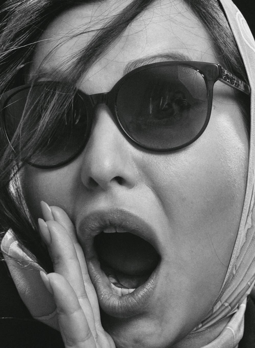 woman wearing black sunglasses showing her tongue