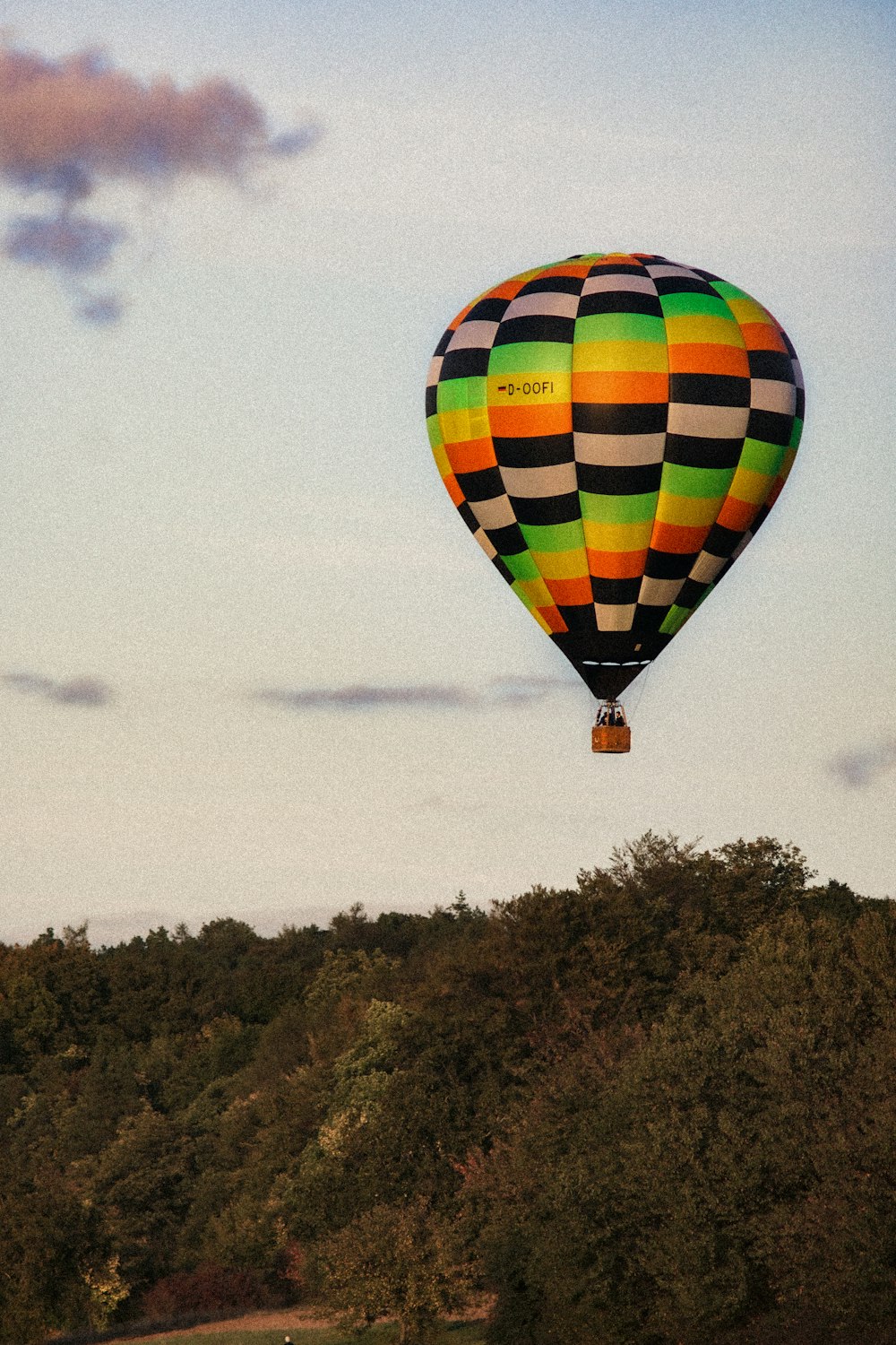 Montgolfière jaune, rouge et bleue en plein vol pendant la journée