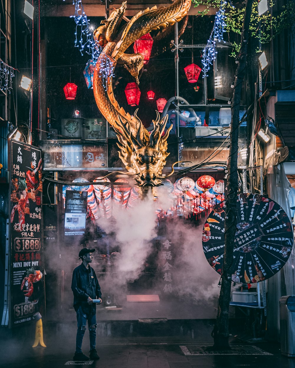 man in black jacket standing in front of store with yellow and red dragon