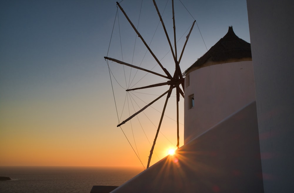 wind turbine near body of water during sunset