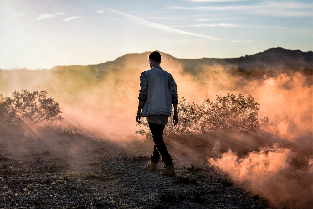 man in white dress shirt and black pants standing on brown soil during daytime