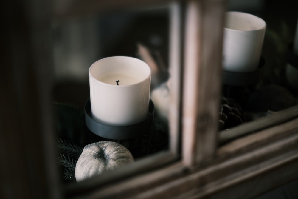 white pillar candle on brown wooden window