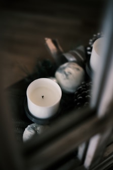 white pillar candle on brown wooden table