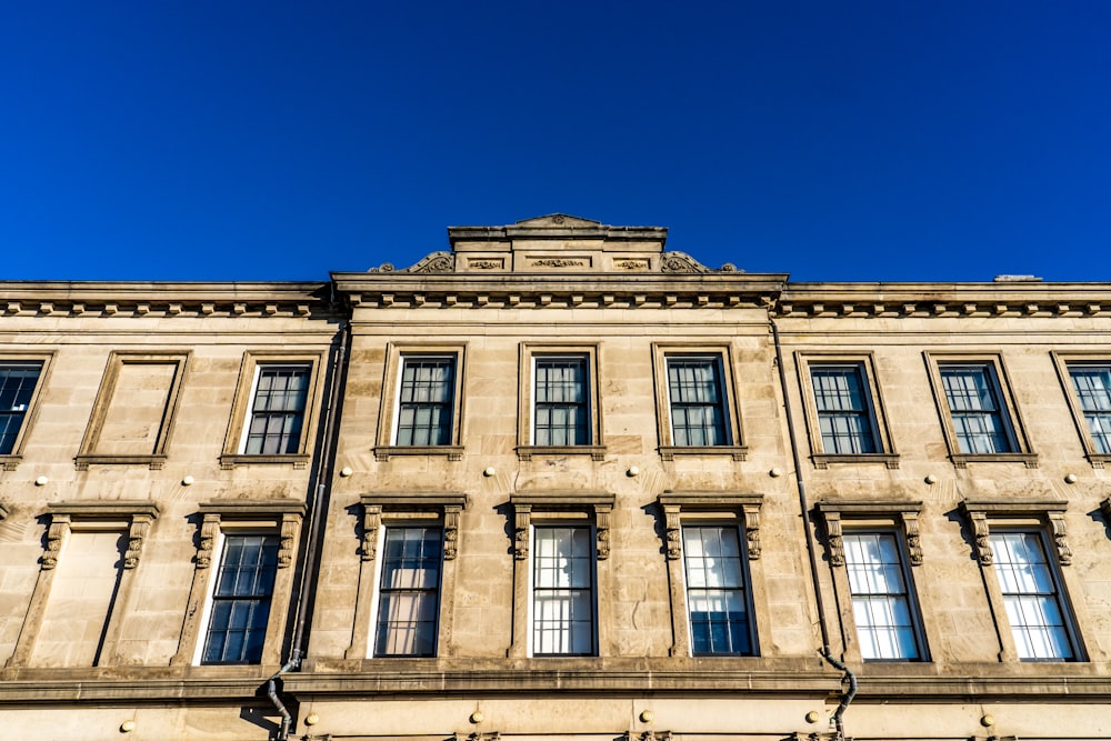 Edificio de hormigón beige bajo el cielo azul durante el día