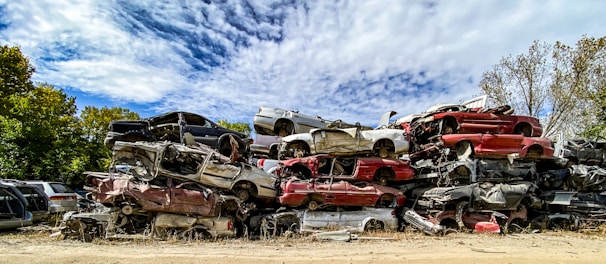 Stacks of old cars ready for recycling under a clear Texas sky at the salvage yard.