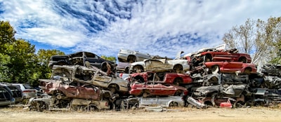 Stacks of salvaged car parts neatly organized in an outdoor yard under a clear sky.