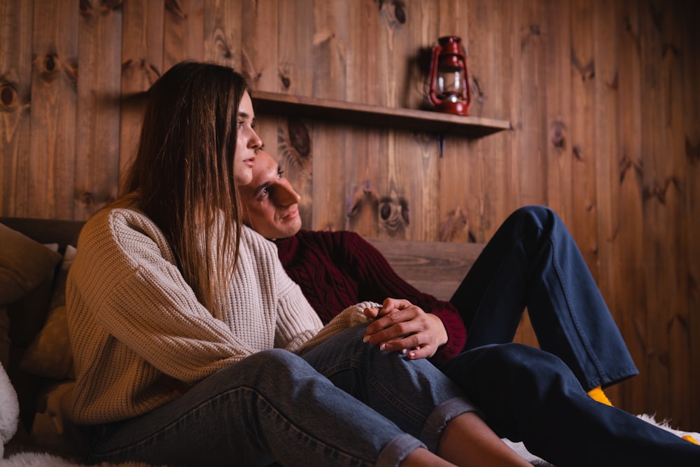 woman in white and black striped long sleeve shirt sitting beside man in black sweater