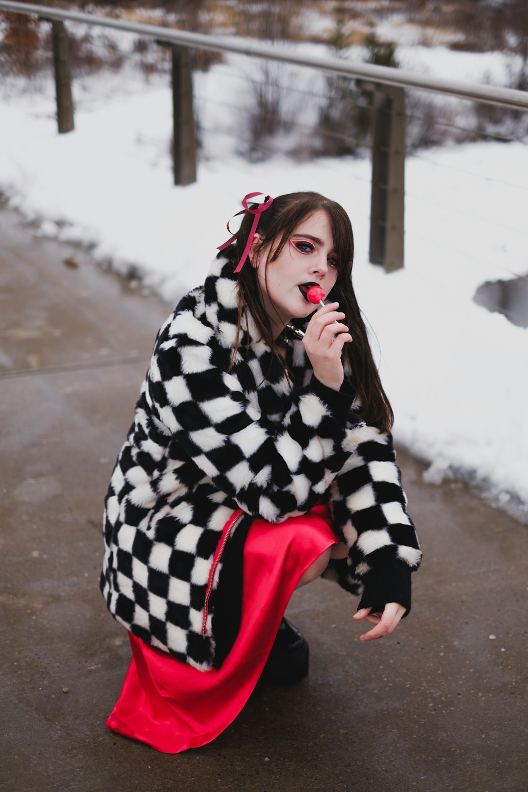 woman in black and white checkered coat sitting on red chair