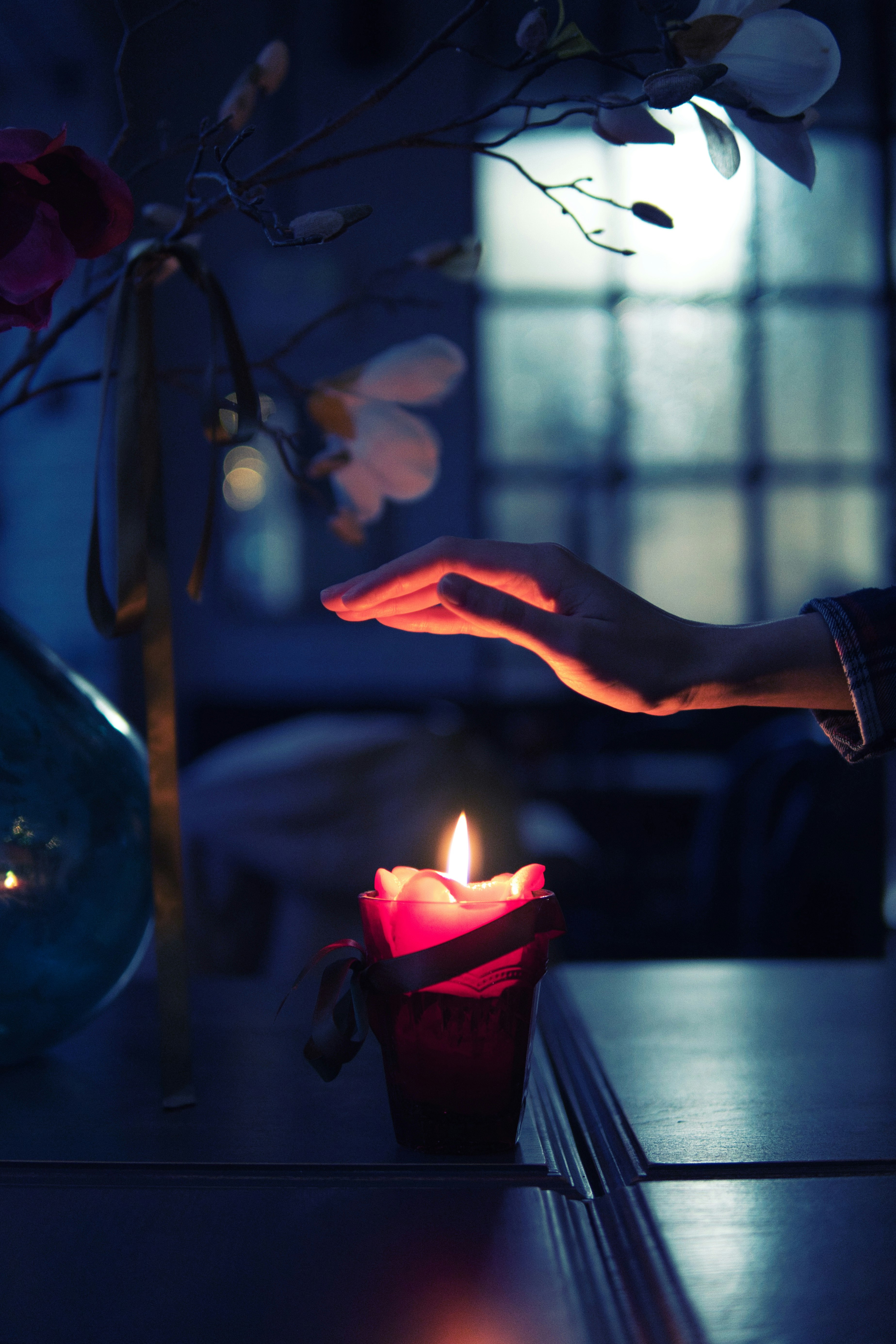 person holding lighted candle on table