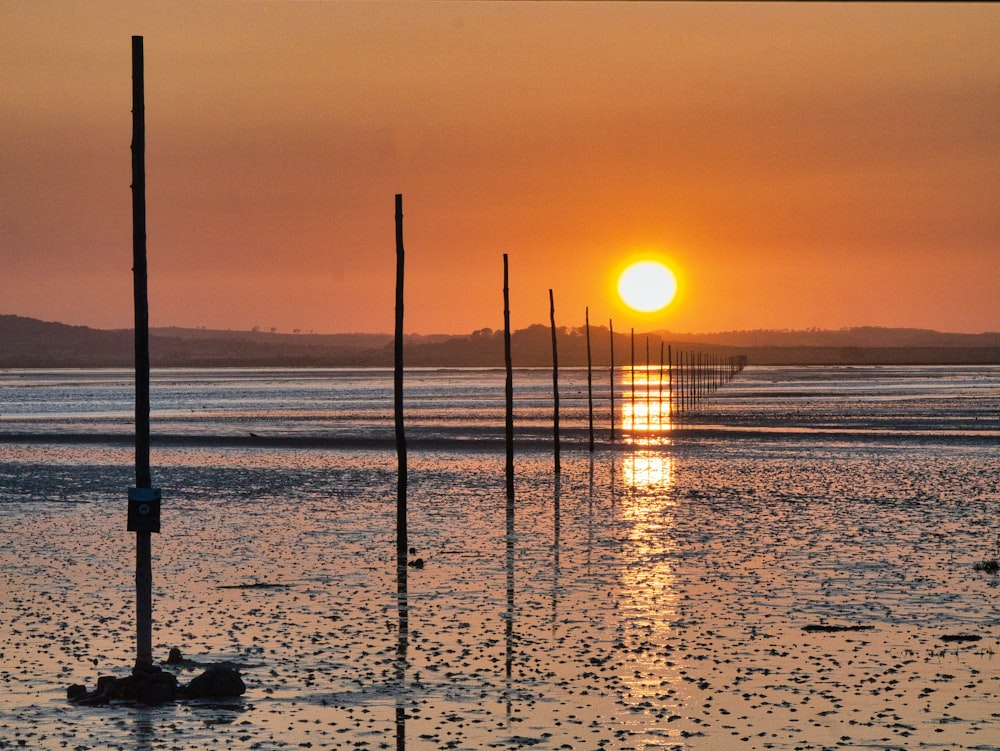 silhouette of post on sea during sunset