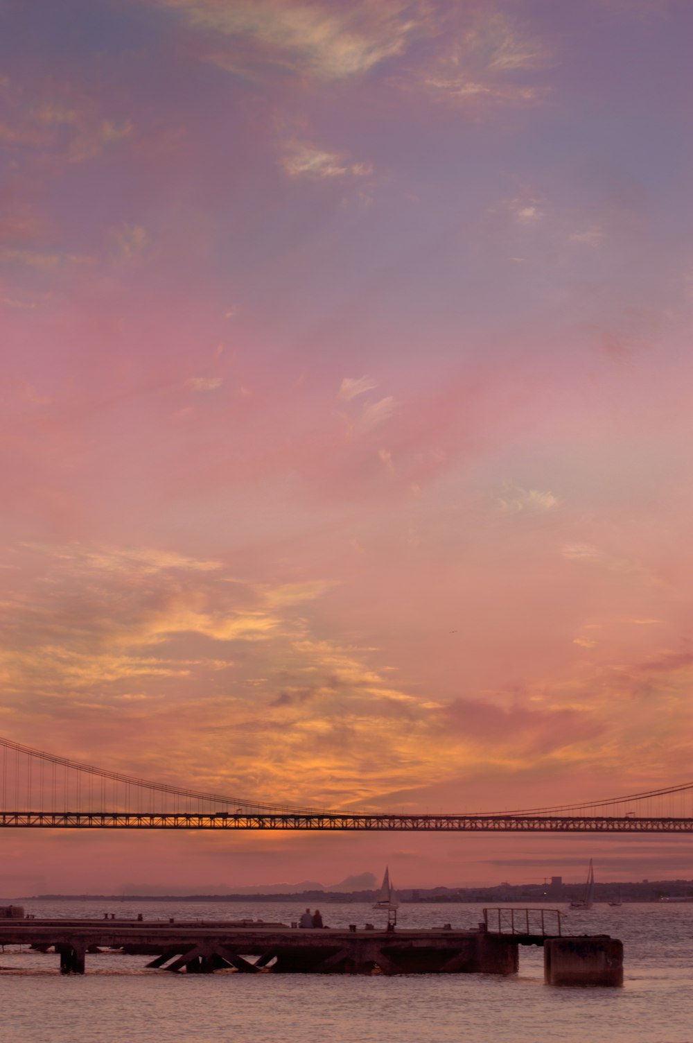 bridge under cloudy sky during sunset